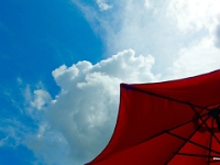 62490CrLe - Clouds above our patio umbrella.JPG